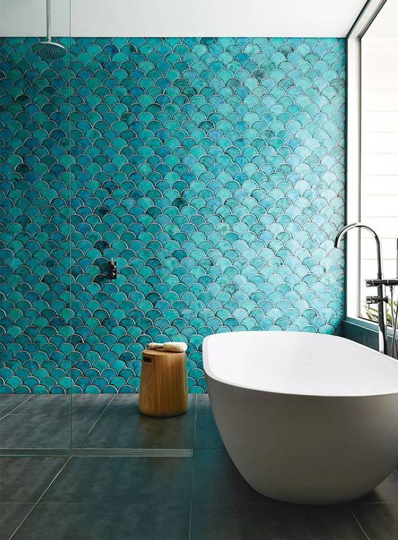 a bold turquoise fish scale tile wall is a statement in the bathroom, and neutral grey tiles on the floor