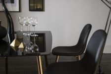 23 a fantastic dining table of a smoekd glass tabletop and copper legs and black leather chairs with copper legs for a moody dining room