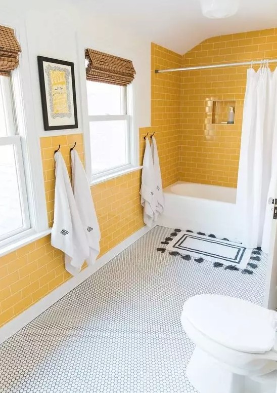 a cheerful bathroom with yellow tile walls, a penny tile floor and white appliances for a chic look