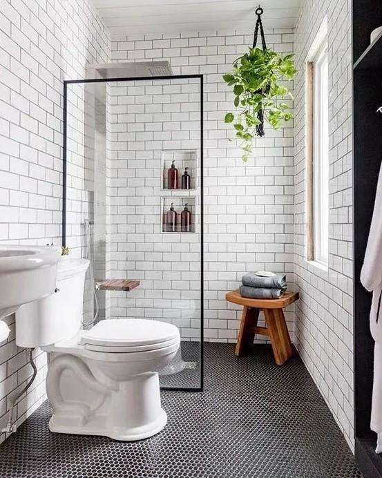a contemporary bathroom with penny and subway tiles, built-in shelves, a sink and a wooden stool