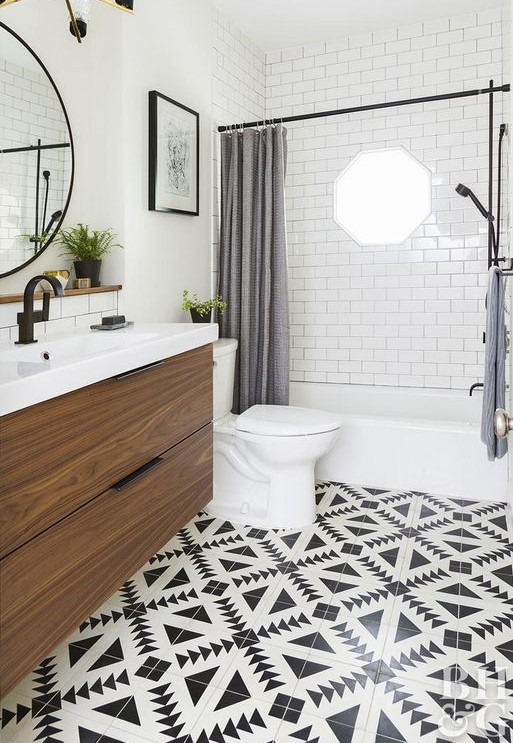 a farmhouse bathroom with a black and white tile floor, grey curtains, a floating vanity and black fixtures for a modern feel