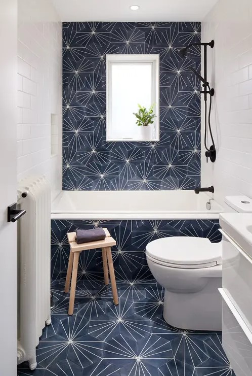 a small modern bathtoom with eye-catchy hexagon tiles, white appliances and black fixtures