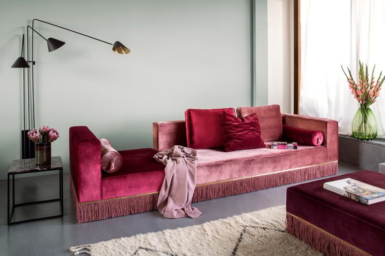 The living room is styled with adorable velvet furniture in jewel tones with fringe