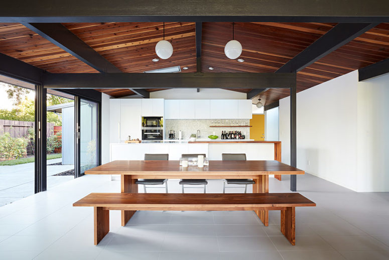The main space is an open layout with a kitchen, dining and living space, with a glazed wall and skylights