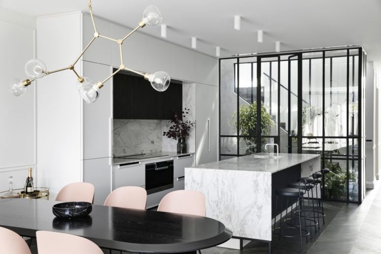 a contemporary kitchen design with stone countertops The kitchen is done in white and with white stone countertops and a backsplash, it flows into a dining space