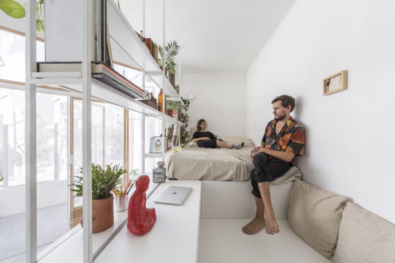 This is a sleeping nook with a built-in bed and a platform for working plus some airy shelves and a desk