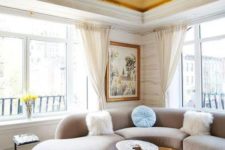 04 a chic and refined living room with elegant curved furniture and a gold ceiling that echoes the furniture base