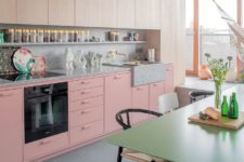 05 The kitchen is done with wooden and pink cabinets and a terrazzo countertop and backsplash