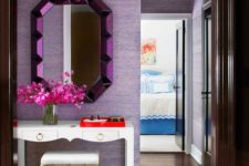 05 a bright entryway with lilac wallpaper walls and a purple mirror, gold touches add a glam feel to the space