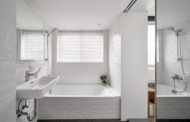 a small yet cute bathroom in white The bathroom is clad with white tiles, there's a covered window to have natural light yet privacy
