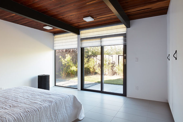 A partly glazed wall can be opened to outdoors and covered with Roman shades when the owners want some privacy