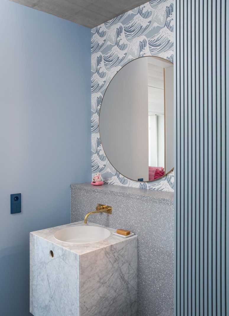 The bathroom features greys and blues, there's stone, terrazzo, wallpaper and paint to bring more textures in