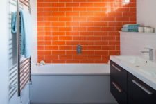 08 a bright touch in the bathroom is done with a bright orange tile statement wall