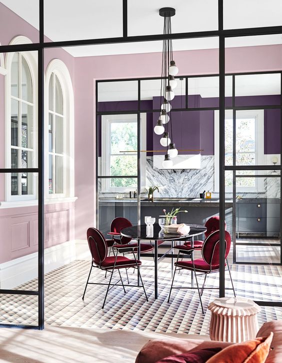 a kitchen with purple walls and grey cabinets and a dining space accented with lilac walls to separate it from the kitchen