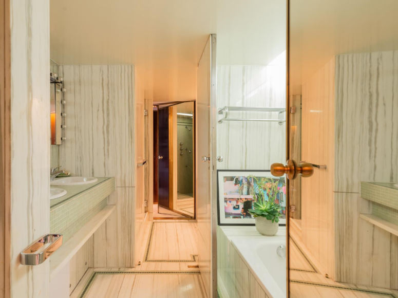 The master bathroom is done with white stone and mitn tiles, it's large and welcoming