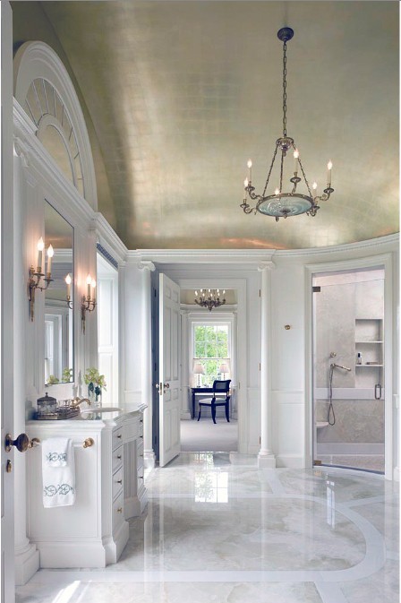 a beautiful traditional bathroom done with white marble and with a shiny gold domed ceiling