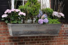 12 a distressed wood window box with pastel blooms and foliage adds a cozy feel and traditional touch