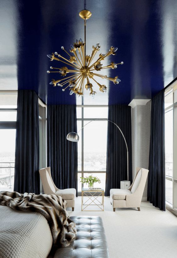 a shiny navy ceiling is a cool way to add a touch of color and a moody feel to the monochromatic bedroom