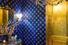 13 an exquisite and super chic powder room done with a gold door, a gold vanity and a ceiling that matches
