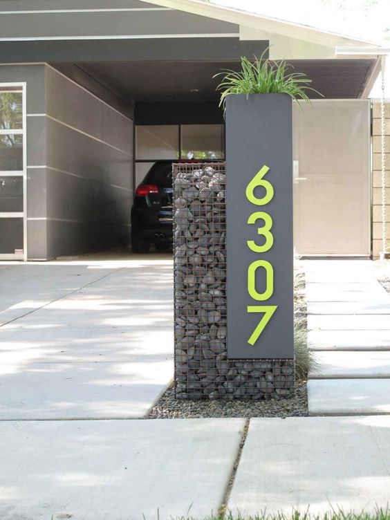 a grey sign with neon green numbers looks ultra-modern and bold and hints on the contemporary decor inside