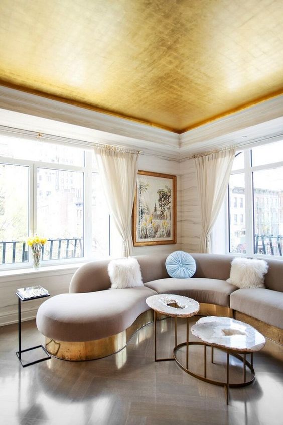 a shiny gold ceiling echoes with the furniture bases and makes the space more glam