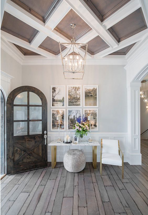 a chocolate brown and white coffered ceiling adds a refined and chic touch to the entryway and brigns timeless elegance