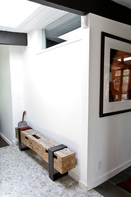 a statement rough wooden beanch with blackened steel legs looks very industrial