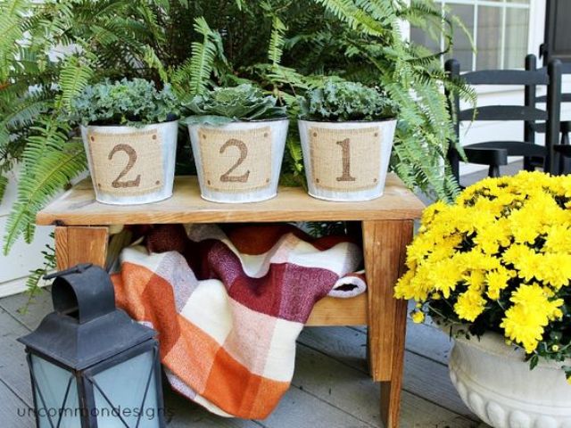 a front porch with a table and planters on them, plant something and add burlap house numbers on it for a rustic feel