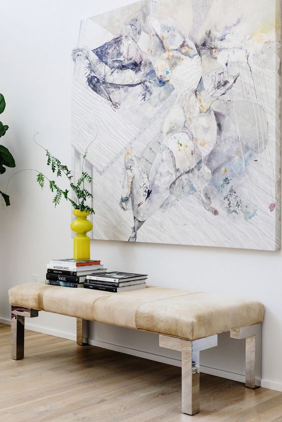 a modern bench with metallic legs and a light-colroed upholstered seat is a great space