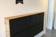 20 an IKEA Trones cabinet in black with a light-colored wooden waterfall tabletop is a bold Scandinavian option