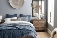 20 create a soothing space with a grey and blue bedding set with various prints and a navy and neutral rug
