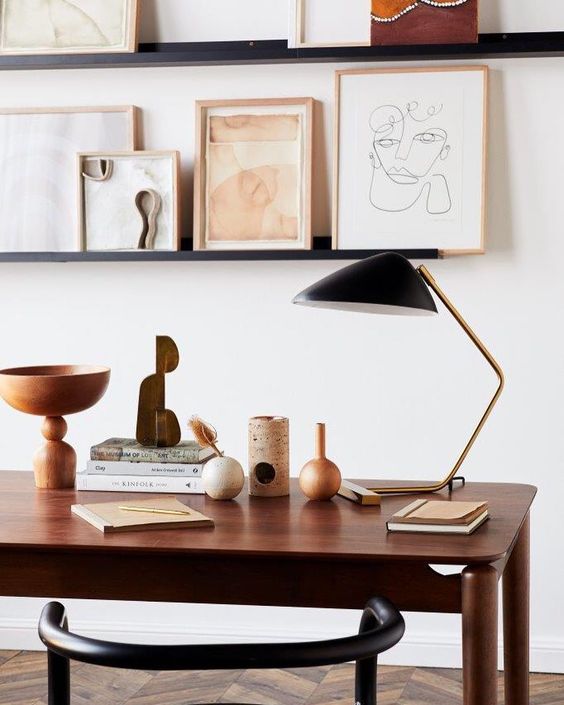 a gallery wall created on ledges opposite the desk is great idea, you may also use them for storing books and papers