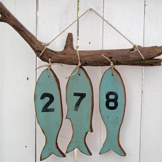 hang a piece of driftwood with wooden fish and house numbers on them is a nice idea for a beach home, hang it on the porch