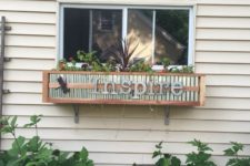 26 a DIY wood and tin window box planter with greenery and other plants and some letters