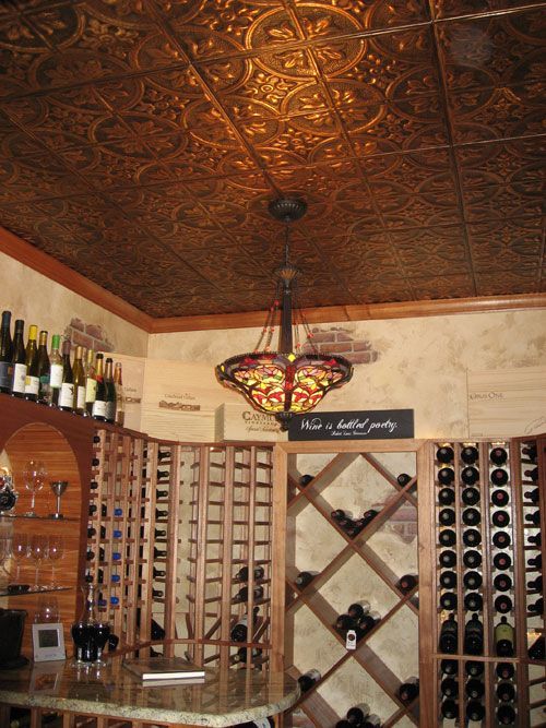 a home wine cellar spruced up with a pressed tin ceiling that gives a chic and vintage feel to the space
