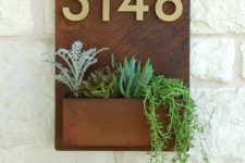 a wall-mount house number combined with a succulent planter