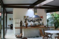 29 a tropical open layout done with tiles, wood and a corrugated steel ceiling that adds an industrial feel