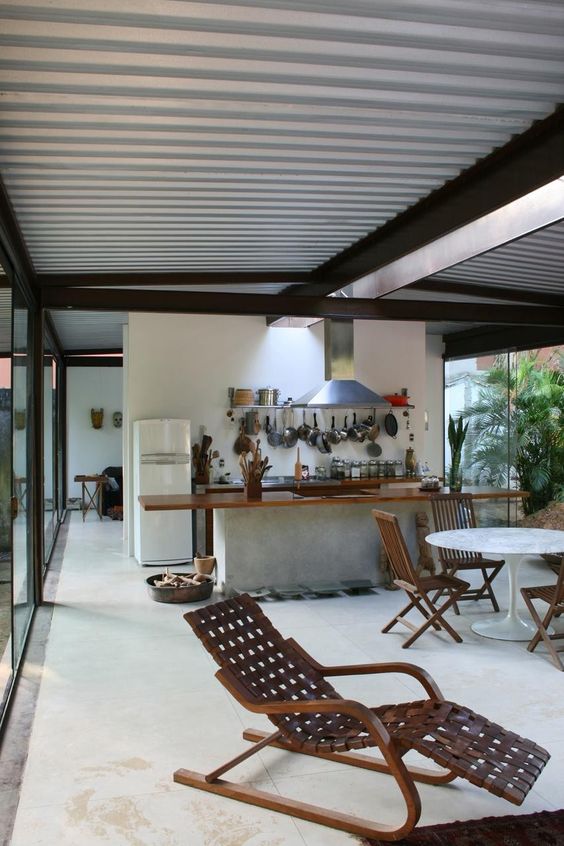 a tropical open layout done with tiles, wood and a corrugated steel ceiling that adds an industrial feel