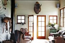 31 an entryway of a rustic hut with a corrugated steel ceiling and a matching wall for a rustic feel