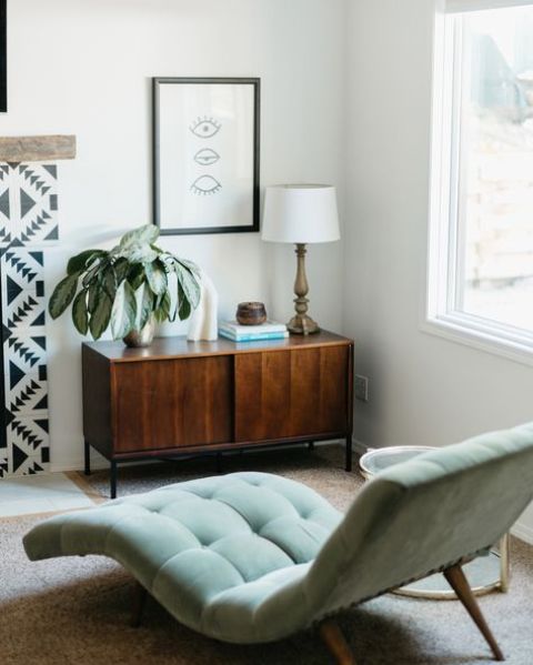 an aqua-colored curved lounger placed by the window is a cool piece to read and relax here