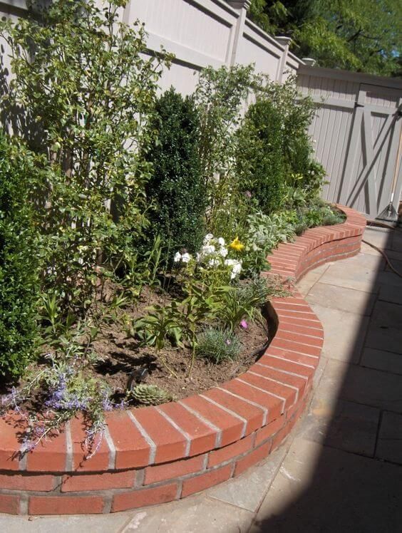 Image of Brick raised flower bed with curved edge