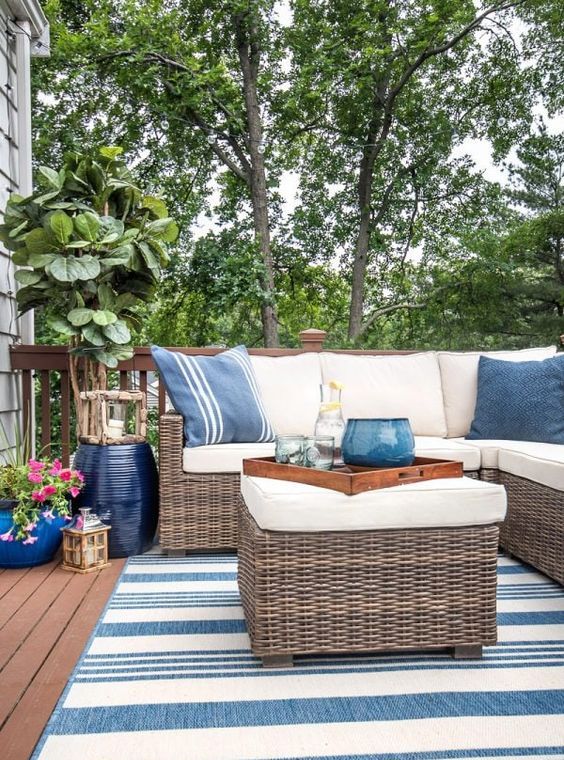 a fresh summer patio done in blues and white, with stripes and wicker furniture and planters