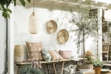 08 a welcoming boho tropical patio with a rattan table, a wooden bench with plenty of pillows, wicker planters and decorative baskets
