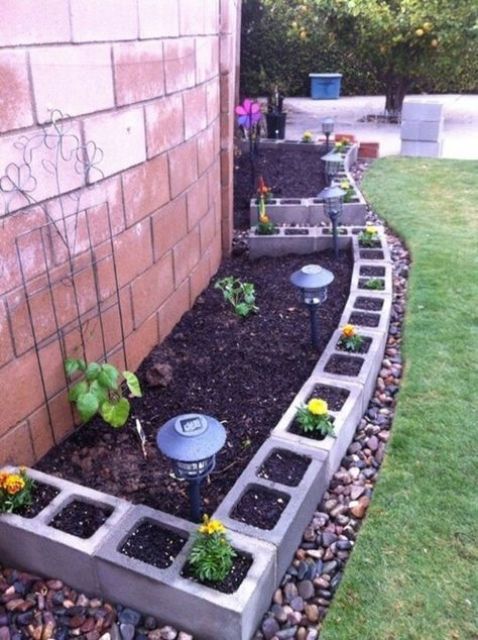 concrete planters framing the garden bed and shaping it, with lamps in the corners