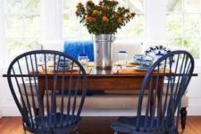 10 a beach-inspired dining space with navy chairs and touches of bold blue plus a printed lampshade