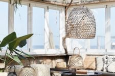 10 a boho chic tropical patio with a large upholstered bench, rattan and metal lanterns and a boho rug plus potted greenery