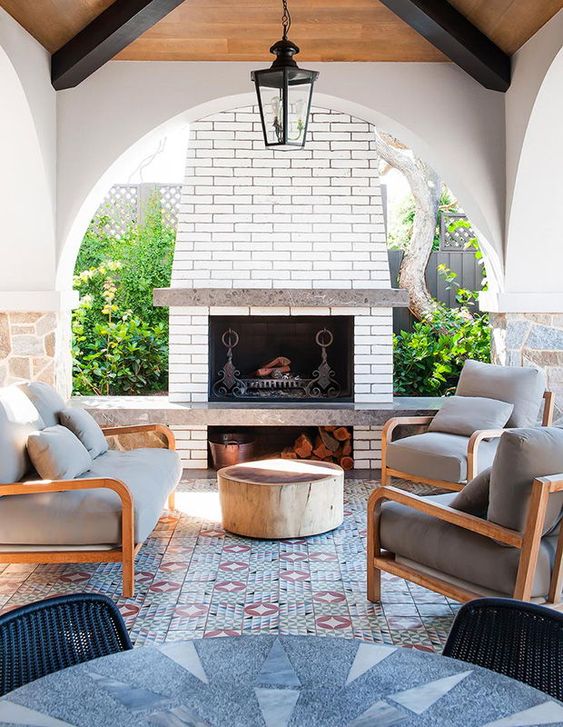 https://www.digsdigs.com/photos/2019/03/12-a-bright-outdoor-lounge-with-a-fireplace-a-mosaic-tile-floor-and-a-bold-table-plus-comfy-chairs.jpg