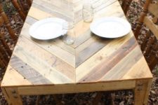 13 an outdoor dining table with a chevron pattern on the tabletop fully built of pallet wood and vintage chairs