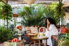 16 a bright boho tropical patio with a tent on top, boho textiles, colorful pillows and lots of potted plants around
