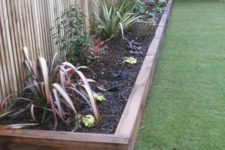 16 stained wood garden bed edging and matching pathways for a relaxed boho feel in your garden